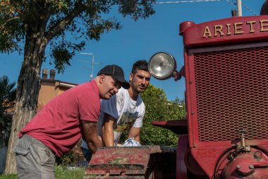 İtalyan çocuklar Bubba Ariete 'nin motorunu çalıştırıyor, kızgın başlı traktör.