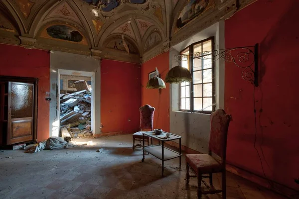 Eylül 2021, İtalya. Terk edilmiş bir şatoda oturma odası. Masası, sandalyeleri ve çay servisi var. Urbex