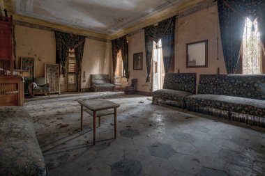 İtalya, 20 Ocak 2021. Terk edilmiş bir evde kocaman bir oturma odası. Koltukların döşemesi, perdelerde kullanılanla aynı. urbex