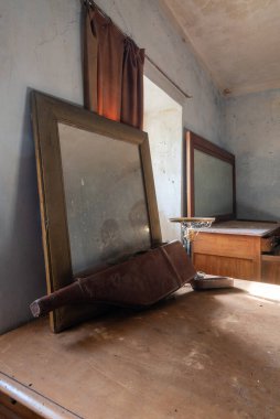 İtalya, 20 Ocak 2021. Eski model. Eski bir ayna ve bir silah kılıfı, bir mobilyanın üzerinde duruyor. Terk edilmiş bir evde. urbex