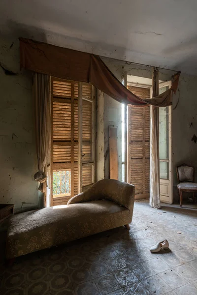 İtalya, 20 Ocak 2021. Terk edilmiş bir evin yatak odasında eski bir şezlong. urbex