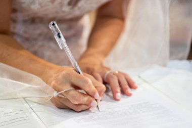 Mart 2022, genç gelinin eli evlilik kaydını imzalıyor.