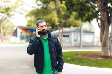 Sakallı adam cep telefonu üzerinde konuşurken