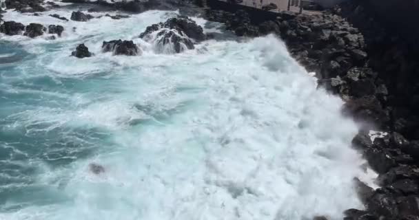 Aerial shot of waves crashing hard against a cliff on the beach — Stock Video