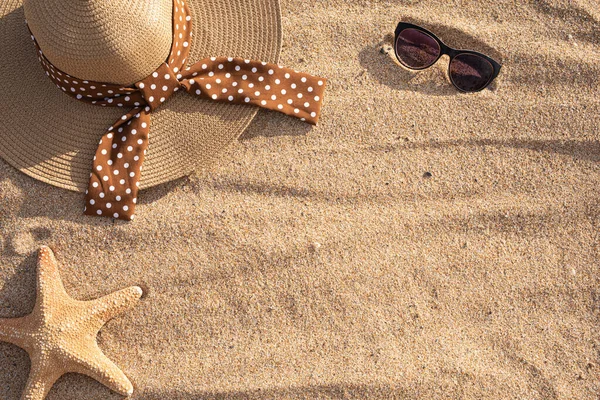 Şapka, güneş gözlüğü ve deniz yıldızı sahilin kumlarında fotokopi alanı olan