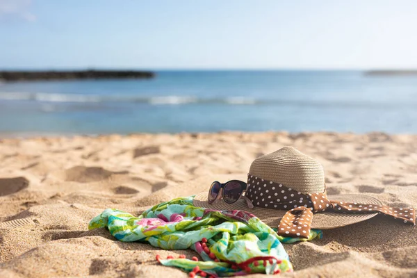 Şapka, güneş gözlüğü ve kumsalda yeşil bir sarong. Yüksek kalite fotoğraf