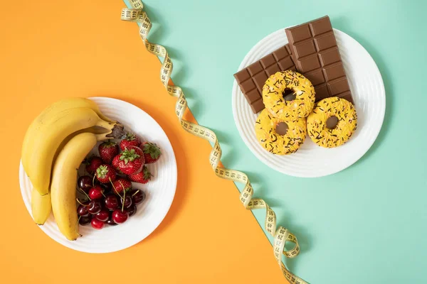 Çilek, kiraz, muz, donut ve çikolata veya diyet konseptinin üst görünümü