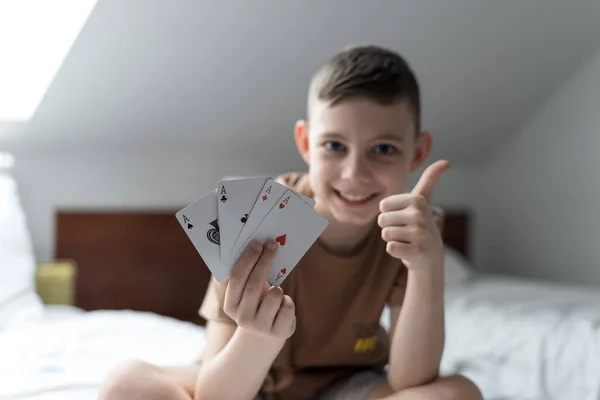 Çocuk kazanır ve elinde iskambil kağıdı tutar ya da odada as gösterir