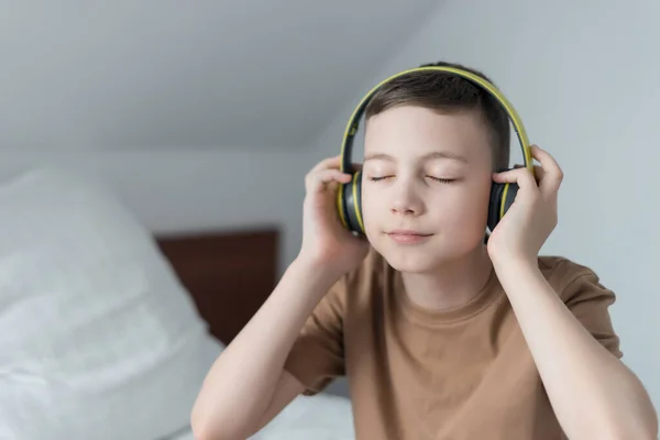 happy kid listen audio song with earphones and relax at home
