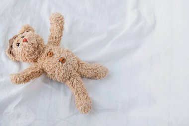 Sevimli küçük bir oyuncak ayı yatağa uzandı..