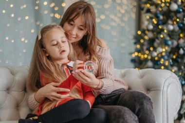 Anne ve kızı evde birlikte oturup Noel sihrini bekliyorlar. Noel arifesinde annemle.