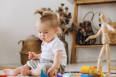 Erken çocukluk gelişimi. Anne ve çocuk arasındaki iletişim. Aile içinde sevgi ve nezaket. Çocuk ahşap çevre dostu oyuncaklarla oynuyor..