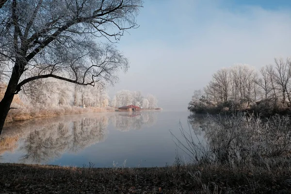 Casa junto ao lago. A transição da natureza do outono para o inverno. manhã nebulosa e ensolarada no lago. — Fotografia de Stock