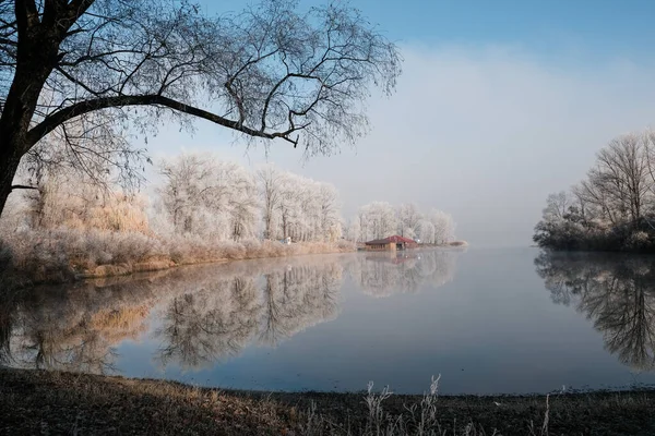 Casa junto ao lago. A transição da natureza do outono para o inverno. manhã nebulosa e ensolarada no lago. — Fotografia de Stock