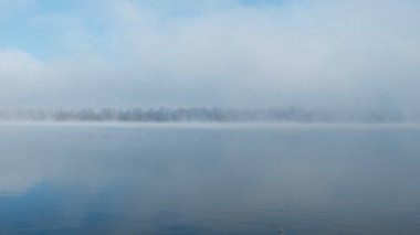 Sonbahar sabahı manzarası. Sis içinde gölün üzerinde gün doğumu. Kışın başlangıcında, ağaçların ve çimlerin üzerindeki yumurtayı. Nadir görülen bir doğa olayı - sis, don ve gün doğumu.