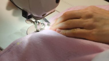 Küçük işletme - dikiş atölyesi. Bir terzi dikiş makinesinde çalışır. Dikiş makinesinin yakın çekimi. Dikiş makinesinin hareketi yukarı ve aşağı iğne yapıyor. Yavaş çekim.