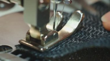 Küçük işletme - dikiş atölyesi. Bir terzi dikiş makinesinde çalışır. Dikiş makinesinin yakın çekimi. Dikiş makinesinin hareketi yukarı ve aşağı iğne yapıyor. Yavaş çekim.