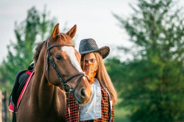cowgirl yakınındaki bir at bir alanda bir şapka ayakta