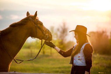cowgirl yakınındaki bir at bir alanda bir şapka ayakta