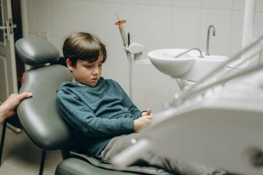 Çocuk dişçiliği. Dişçinin randevusundaki çocuk.