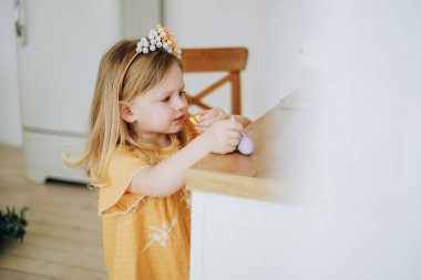 Küçük bir kız Paskalya tatili için hazırlanmış şekerleri yiyor. Kız Paskalya 'dan önce gizlice anne babasından tatlı yiyor..