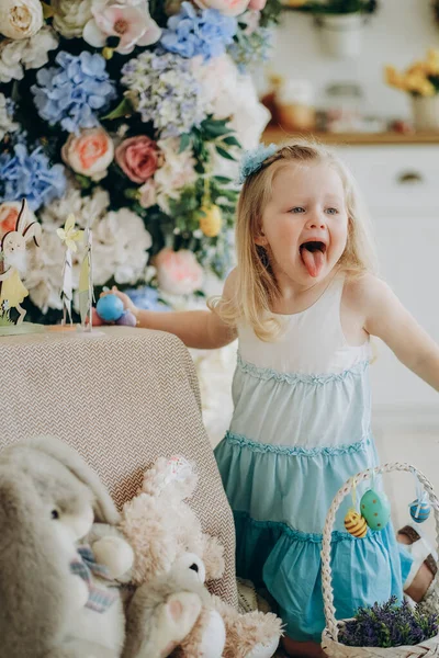 Маленькая девочка играет с красочными яйцами перед Пасхальным праздником. — стоковое фото