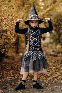 Cadılar Bayramı kutlaması. Cadılar Bayramı için hazırlanmış cadı gibi giyinmiş bir kız. Geleneksel sonbahar bayramı maskeli balosu.