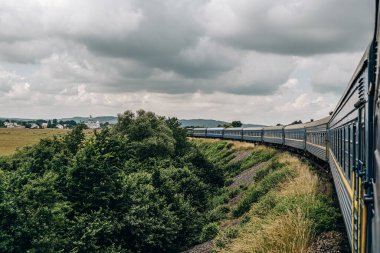 Yazın trenle dağlara seyahat et. Tren penceresinden manzara çok güzel. Yaz tatili dağlarda.
