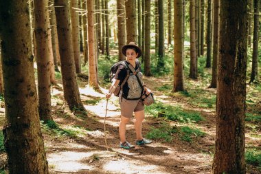 Dağlara yaz gezisi. Yazın ormanda bir kadın yürür. Dağlarda yürüyüş. Yazın aktif tatil.