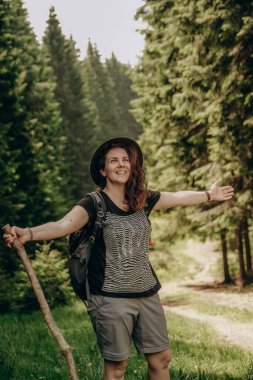 Dağlara yaz gezisi. Yazın ormanda bir kadın yürür. Dağlarda yürüyüş. Yazın aktif tatil.