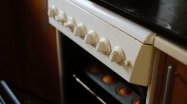 Lezzetli ev yapımı kekler. Bir kadın fırından hazır kek çıkartıyor. Büyükannem pişiriyor. Evde lezzetli ve güzel kokulu kekler pişiriyorlar..