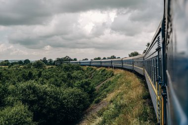 Yazın trenle dağlara seyahat et. Tren penceresinden manzara çok güzel. Yaz tatili dağlarda.