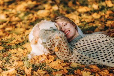 A young blonde woman is playing in the autumn park with her labrador. Evening walk with a labrador. Love for pets.