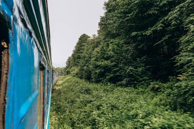 Yazın trenle dağlara seyahat et. Tren penceresinden manzara çok güzel. Yaz tatili dağlarda.