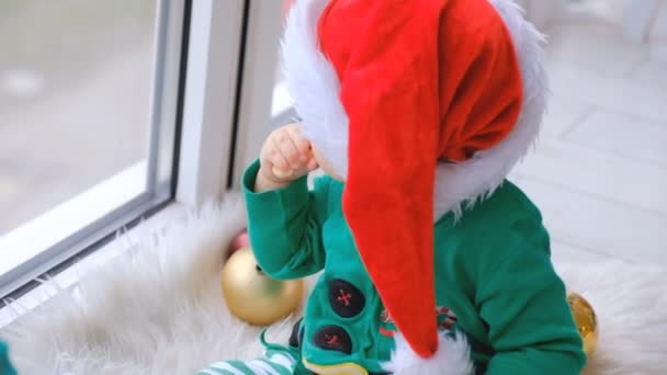 Kid Dressed Santa Sits Window Plays Christmas Decorations Anticipation Holiday — Stock video