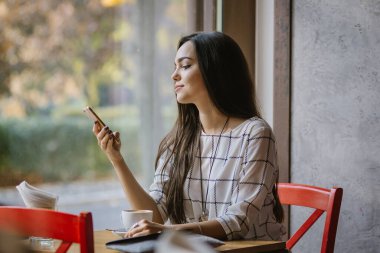 Müslümanların Avrupa 'ya entegrasyonu. Genç ve güzel Müslüman kız Avrupa kültürünü benimsiyor. Genç Müslüman bir kadın kafeteryada tesettürsüz oturuyor..