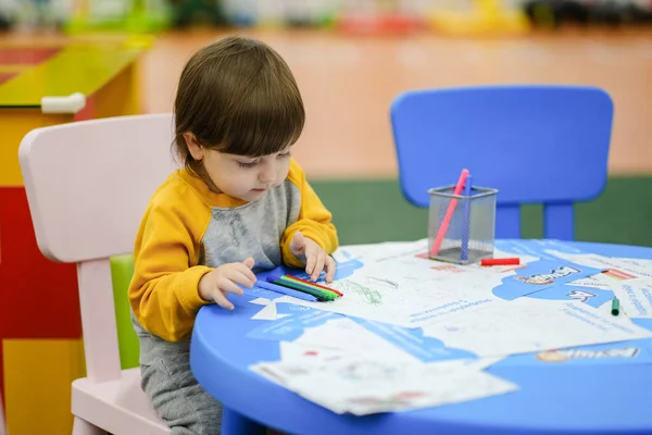 Creative baby development. Baby learns to draw. Early development of children in the Children's Development Center. Happy kid draws.