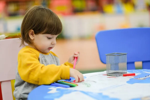 Creative baby development. Baby learns to draw. Early development of children in the Children's Development Center. Happy kid draws.