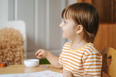 Erken çocuk gelişimi. Çocuğun evde eğitimi. Çocuklara öğretmek için yeni yöntemler ve teknolojiler. Çocukların yaratıcı gelişimi. Çocuk resim yapmayı öğreniyor..