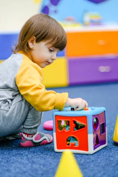 Early baby development. Little boy plays in the children's room. A child plays at an early childhood development center.