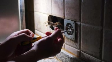 Elektrikçi karanlıkta elektrik prizinin prizini tamir etmiş. Statik çekim. konut yenileme konsepti