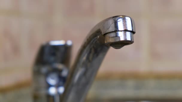 4k. Water Driping from the Tap into a Sink. Close-up.Macro shot of water flowing out of the pipe washstand. Plumbing and household renovation concept. — Stock Video