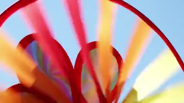 Arc-en-ciel coloré Spinning Pinwheel jouet dans le vent contre le ciel bleu paysage. Énergie alternative — Video