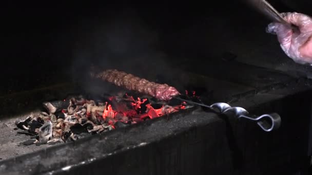 Лула кебаб смажать на раковині з гарячим вугіллям. Концепція вуличної їжі — стокове відео