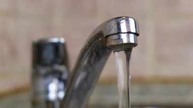 Mutfaktaki musluktan su akıyor. Musluk suyu borusundan su içme ve tesisat kavramı
