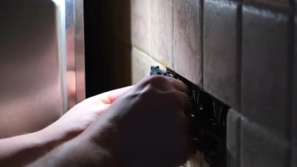 Elektricien repareert een stopcontact in het appartement in het donker. Statisch schot. woningrenovatieconcept — Stockvideo