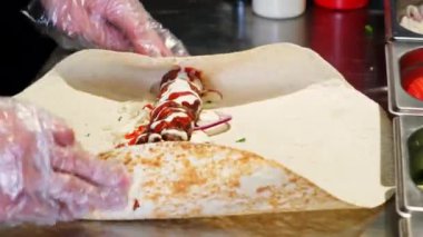 Şef, Türk restoranında lula kebabı pişiriyor. Yuvarlanan kebap ve kıymalı et paketleri Pita Lavash 'a yakın olsun.