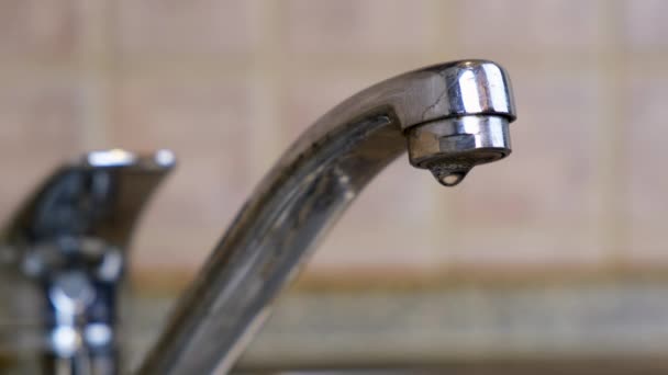 4k. Acqua che sgocciola dal rubinetto in un lavandino. Primo piano Macro shot di acqua che fuoriesce dal lavabo del tubo. Concetto di ristrutturazione idraulica e domestica. — Video Stock