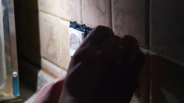 Electrician om repara o priză electrică priză în apartament în întuneric. Lovitură statică. Conceptul de renovare acasă — Videoclip de stoc