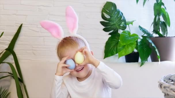 Drôle garçon heureux enfant avec des œufs de Pâques et des oreilles de lapin dansant. Concept de Pâques, enfance heureuse. Chasse aux oeufs de Pâques. Mouvement lent. — Video